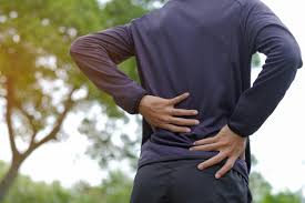 A person holding their lower back in pain